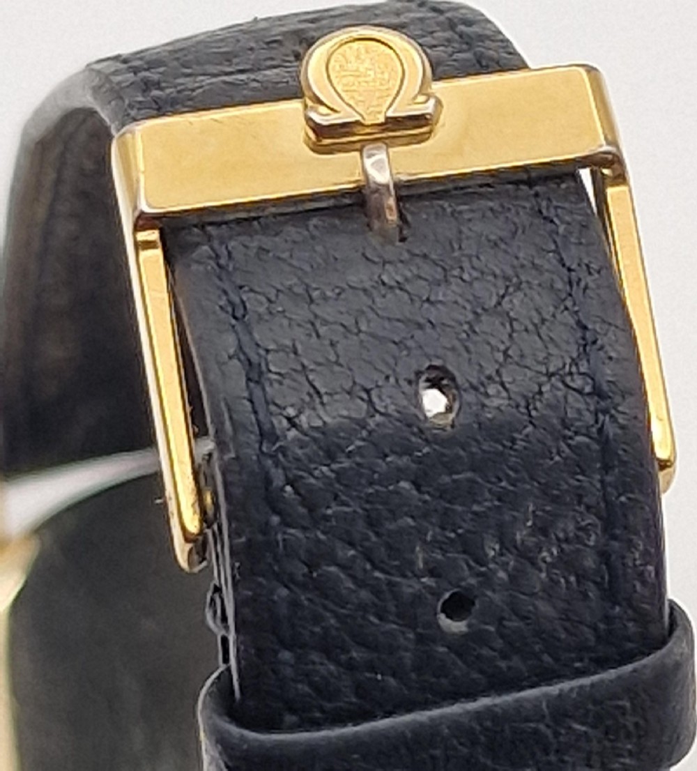A 1954 Omega Century wristwatch with a gold-filled circular case, patinated dial with arrow markers, sub-seconds display, and a black leather strap. View III