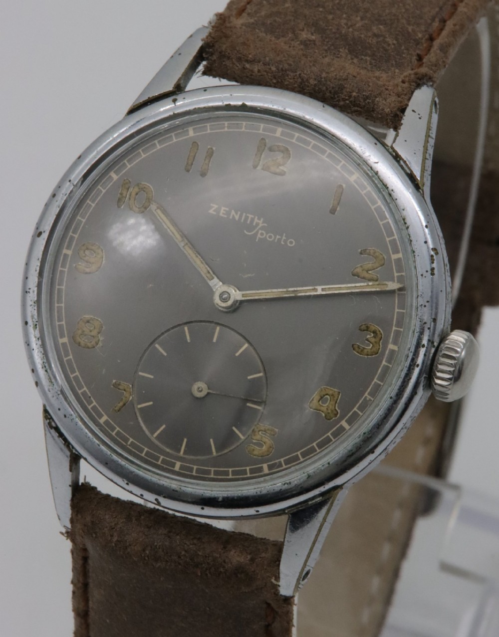 A 1950s Zenith Sporto mechanical wristwatch featuring a grey dial, Arabic numeral hour markers, a sub-seconds dial, and a brown leather strap. View II