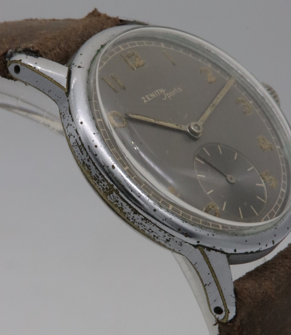 A 1950s Zenith Sporto mechanical wristwatch featuring a grey dial, Arabic numeral hour markers, a sub-seconds dial, and a brown leather strap. View V