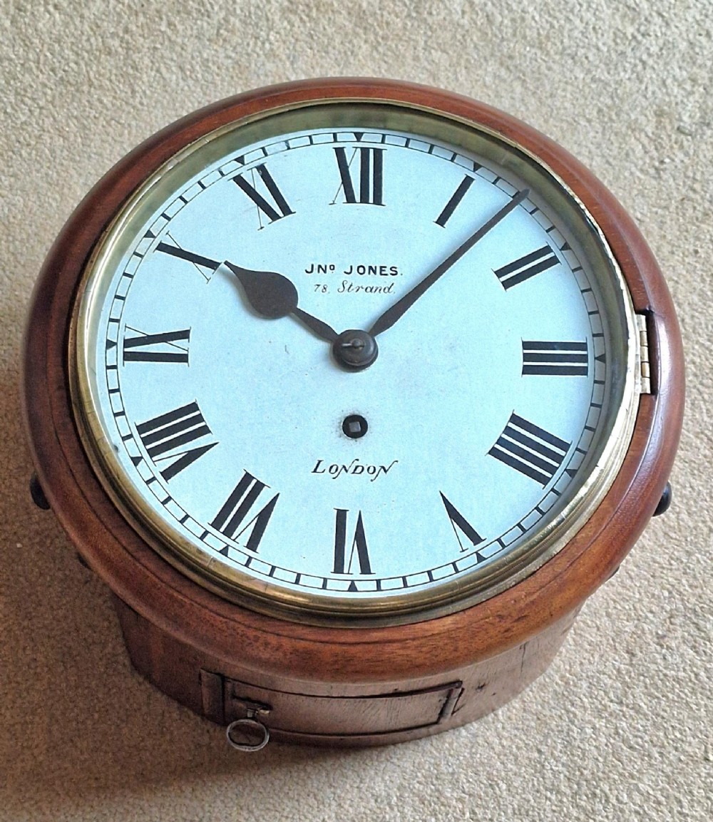 A circular Victorian fusee wall clock set in a turned mahogany case with a white dial, black Roman numerals, and a brass bezel.