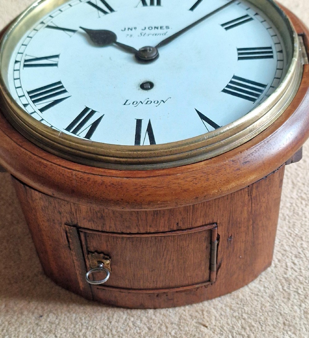 A circular Victorian fusee wall clock set in a turned mahogany case with a white dial, black Roman numerals, and a brass bezel. View II