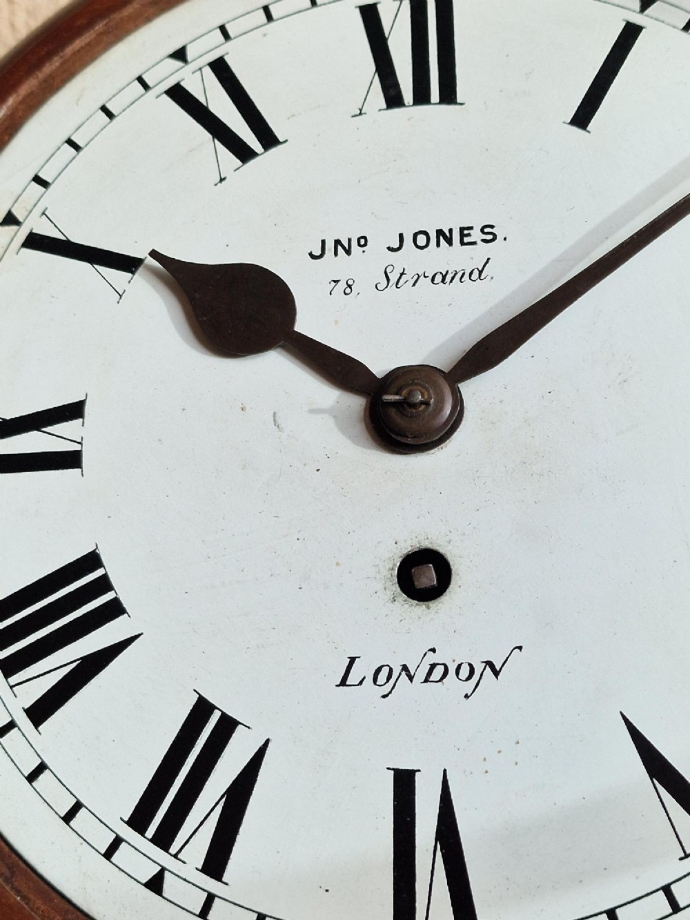 A circular Victorian fusee wall clock set in a turned mahogany case with a white dial, black Roman numerals, and a brass bezel. View III