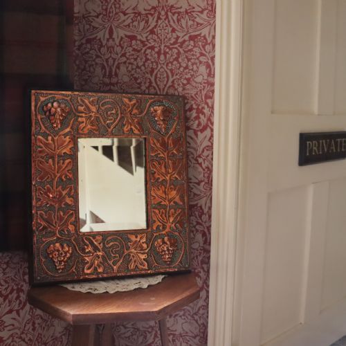 AN ARTS AND CRAFTS COPPER REPOUSS WALL MIRROR - ADDITIONAL PHOTO 1
