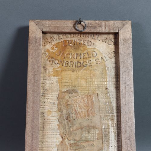 fig 2. A rectangular moulded relief ceramic tile depicting an allegorical maiden with cherubs and birds, finished in an amber translucent glaze and set in a simple dark wooden frame.