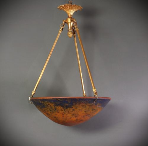 fig 1. An Art Deco glass plafonnier featuring a warm mottled orange and dark blue bowl shade suspended by three gilt metal rods and a decorative ceiling rose.