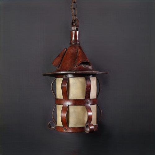 fig 1. An Arts and Crafts hanging lantern featuring a hand-stitched dark brown leather framework surrounding illuminated vellum panels with scrolled metal feet.