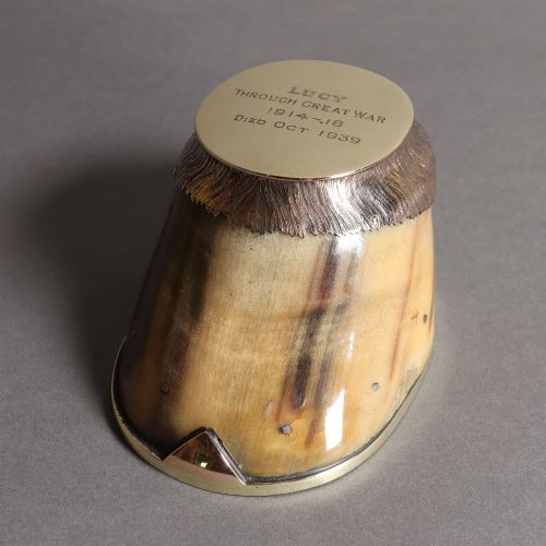 fig 1. A preserved horse hoof mounted with an engraved brass top plate detailing military service dates and fitted with a polished brass rim around the base.