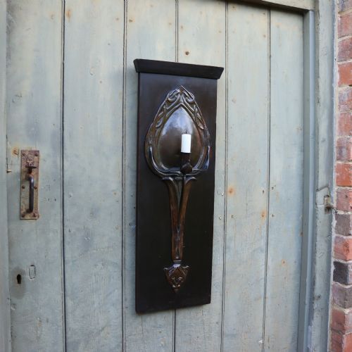 An Arts and Crafts Patinated Copper Wall Sconce