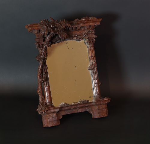 fig 2. A late nineteenth-century Black Forest carved walnut table mirror featuring ornate architectural columns and botanical leaf carvings around the central rectangular mirror glass.