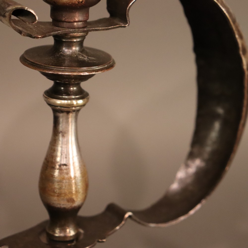 An Arts and Crafts brass table lamp featuring a hand-hammered circular base, a curved handle stem, and a flame-shaped ribbed vaseline glass shade. View V