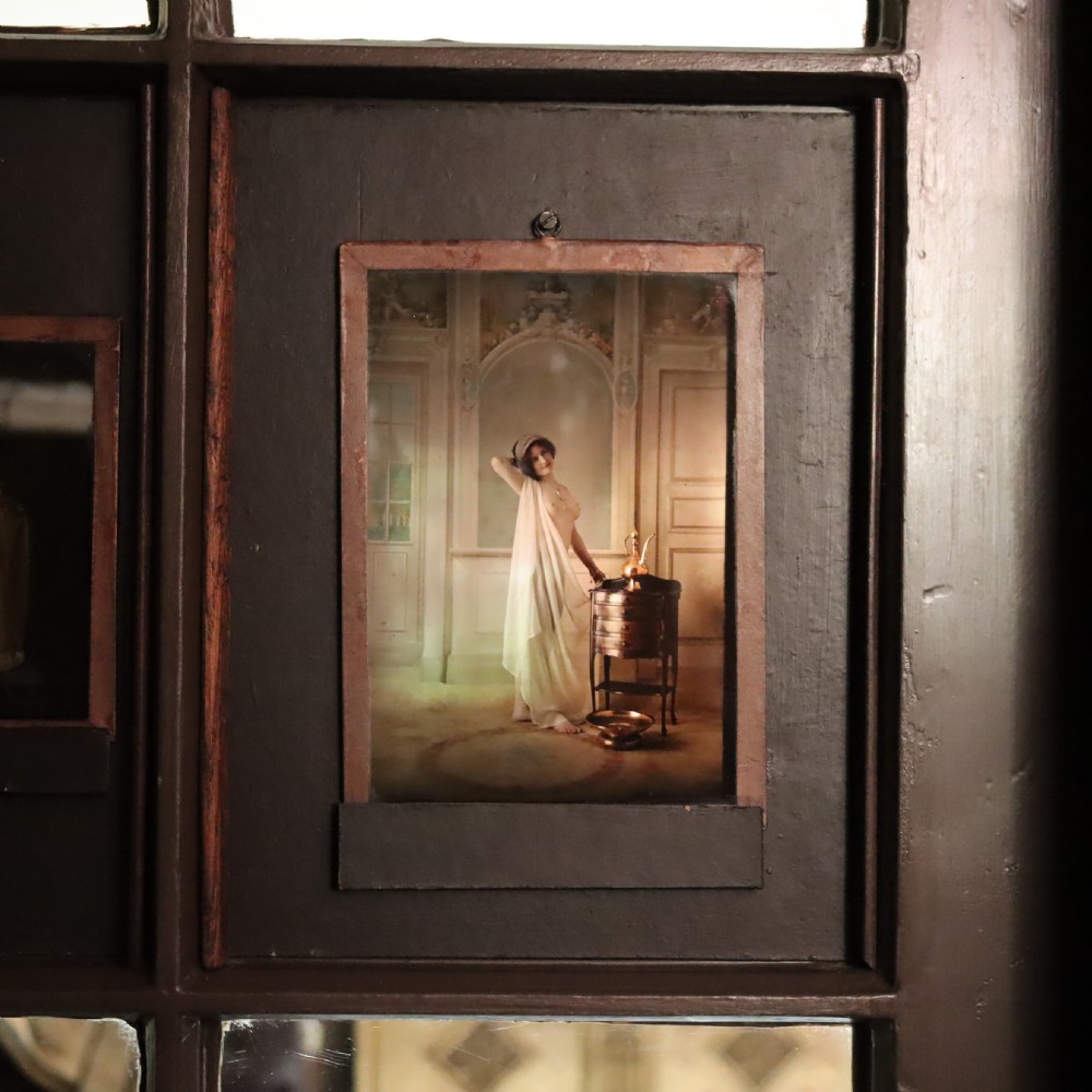 A pair of framed early glass autochrome photographs depicting female figures staged in orientalist interior settings. View V