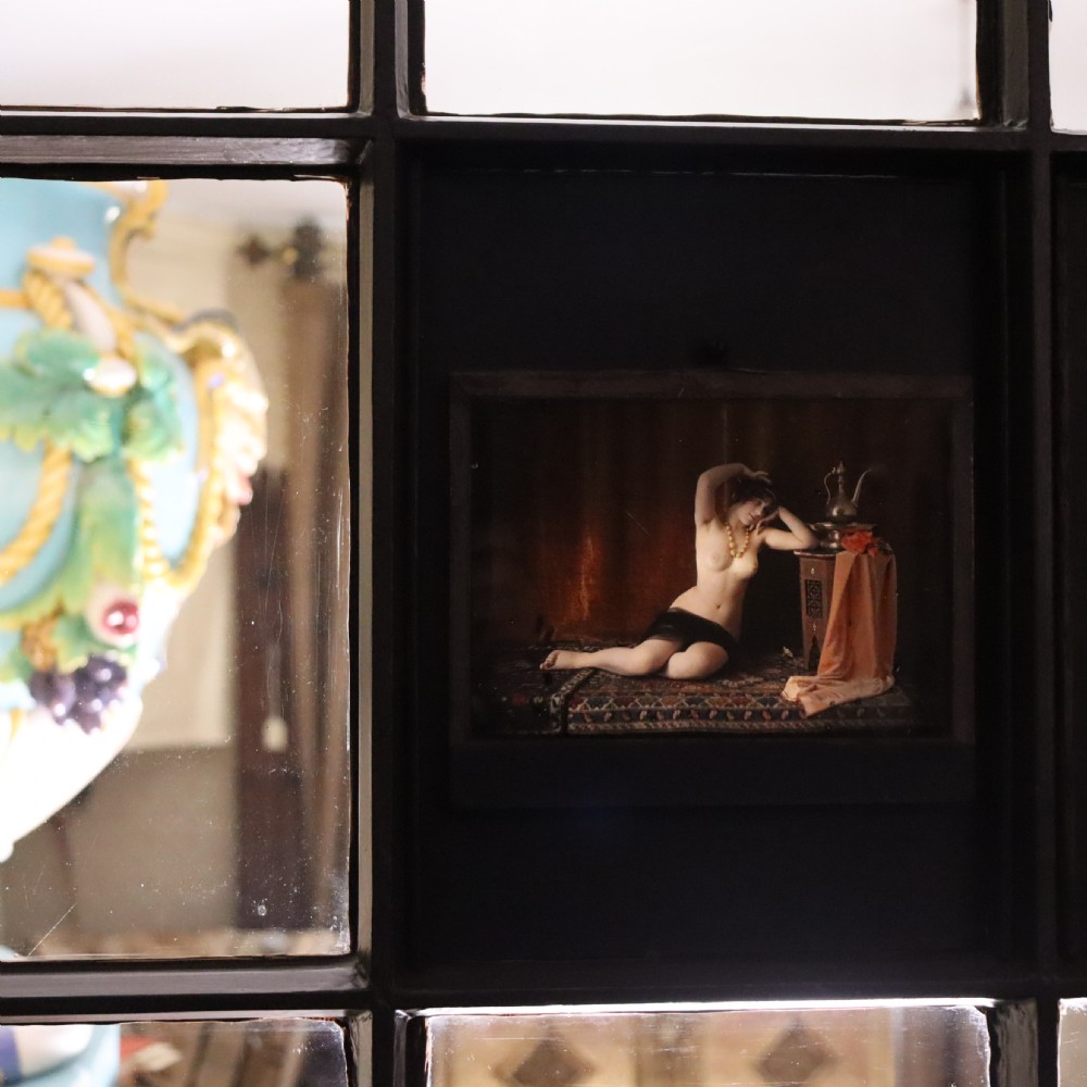 A pair of framed early glass autochrome photographs depicting female figures staged in orientalist interior settings. View VI