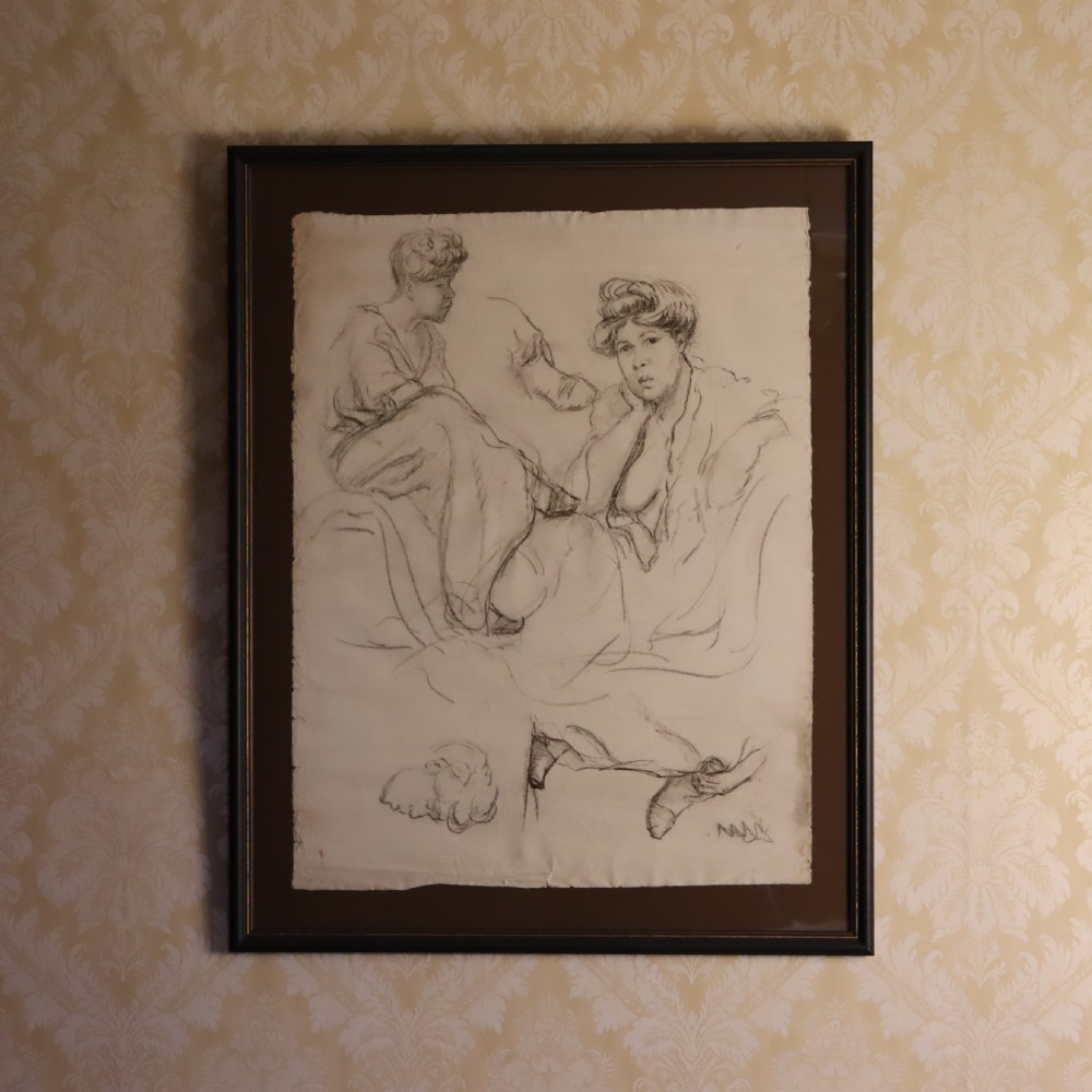 A framed monochrome charcoal drawing on paper depicting two female figure studies mounted within a dark wooden frame.