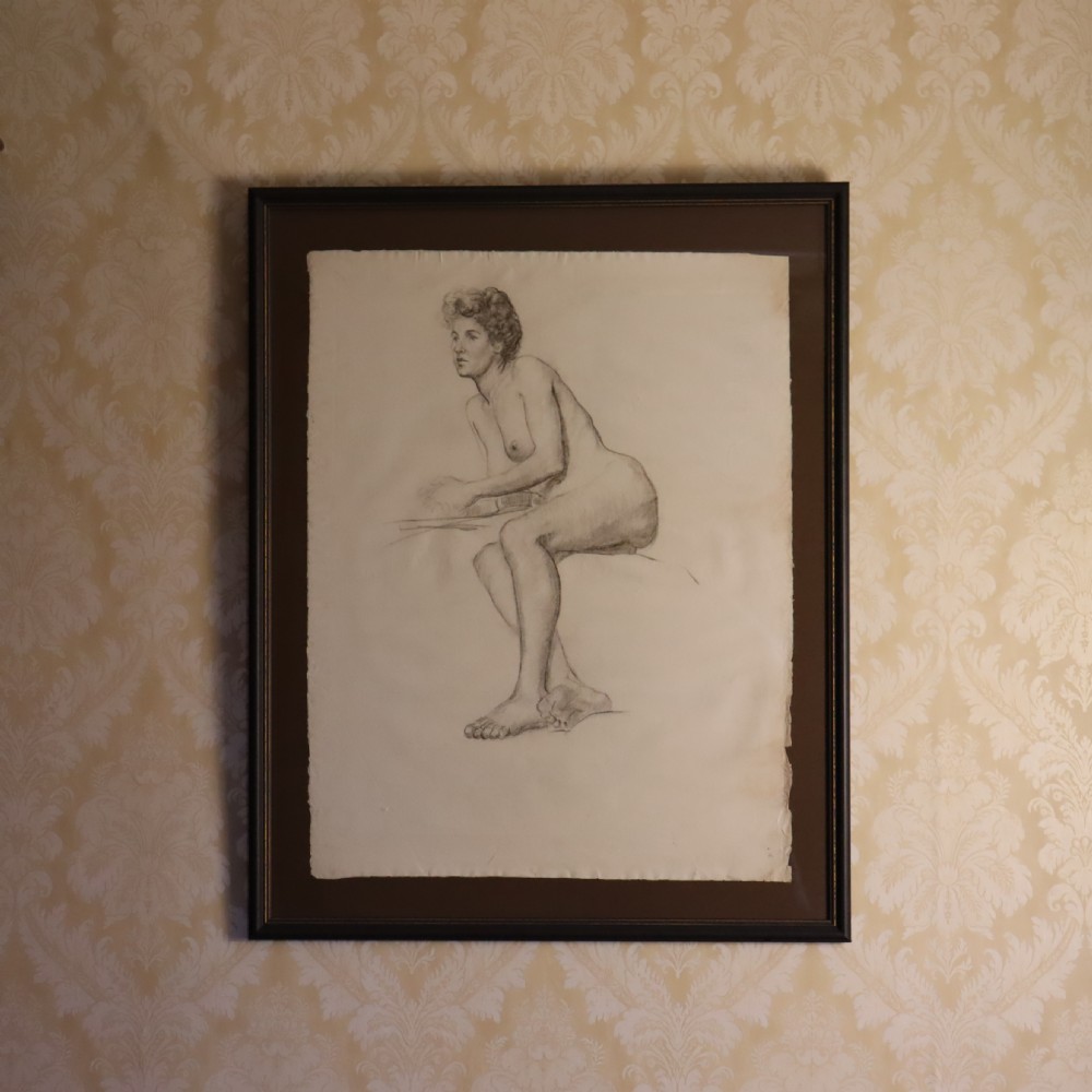 A framed monochrome charcoal drawing on paper depicting two female figure studies mounted within a dark wooden frame. View II