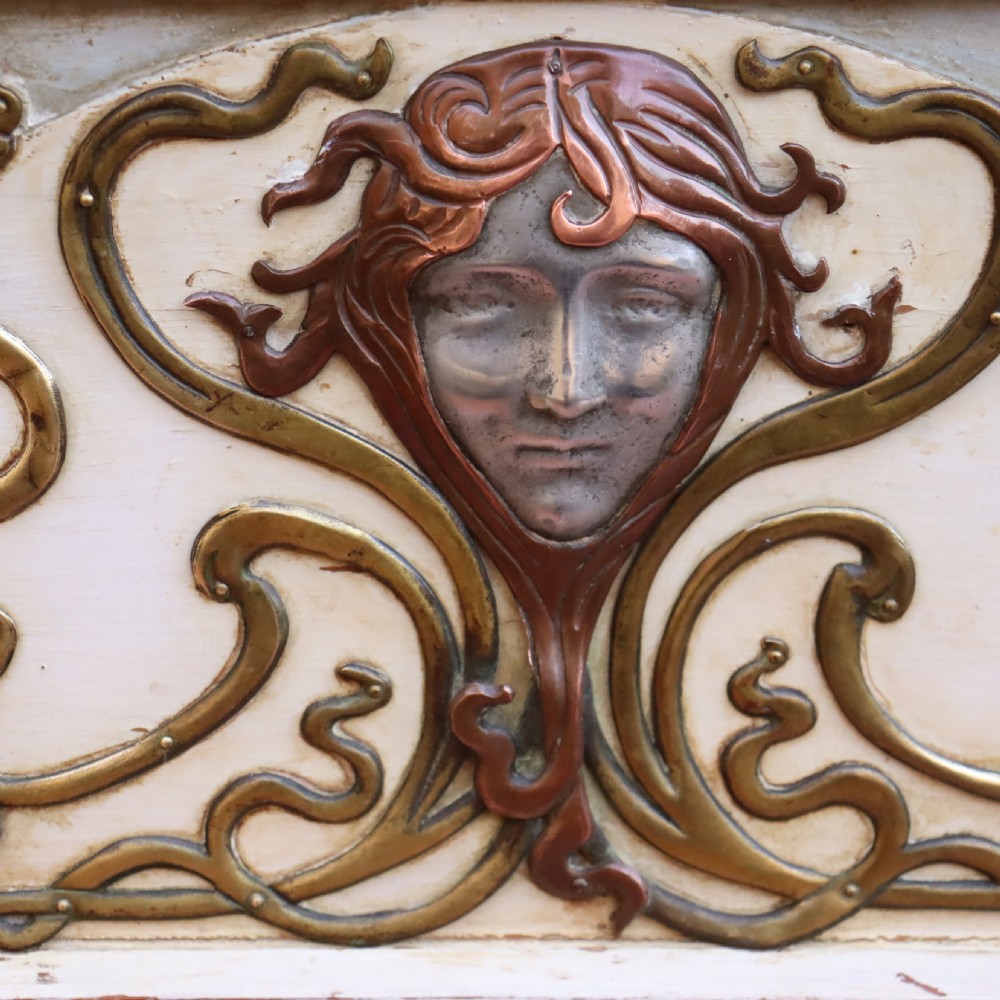 A cream-painted domed Art Nouveau casket featuring gilt metal whiplash scrollwork, a central relief mask, and a Latin inscription around the base. View III