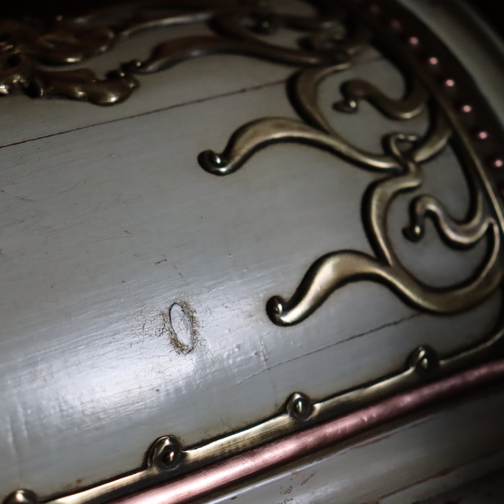 A cream-painted domed Art Nouveau casket featuring gilt metal whiplash scrollwork, a central relief mask, and a Latin inscription around the base. View IX