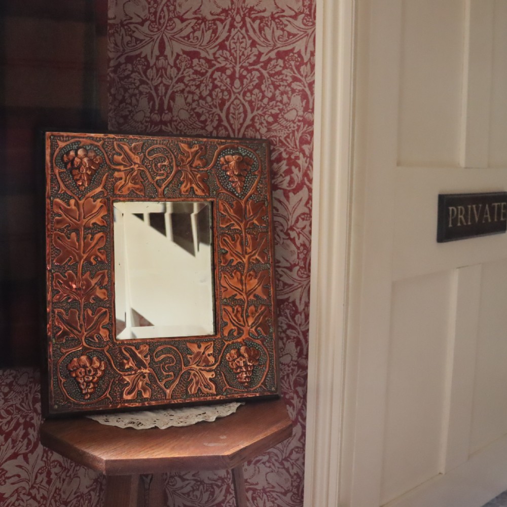 An Arts and Crafts copper repoussé wall mirror  View II