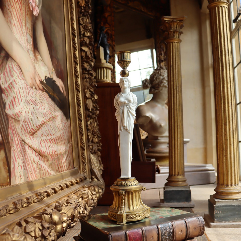 A 19th-century Neoclassical candlestick featuring a chased gilded bronze base and socket holding a sculpted white biscuit porcelain caryatid figure. View V
