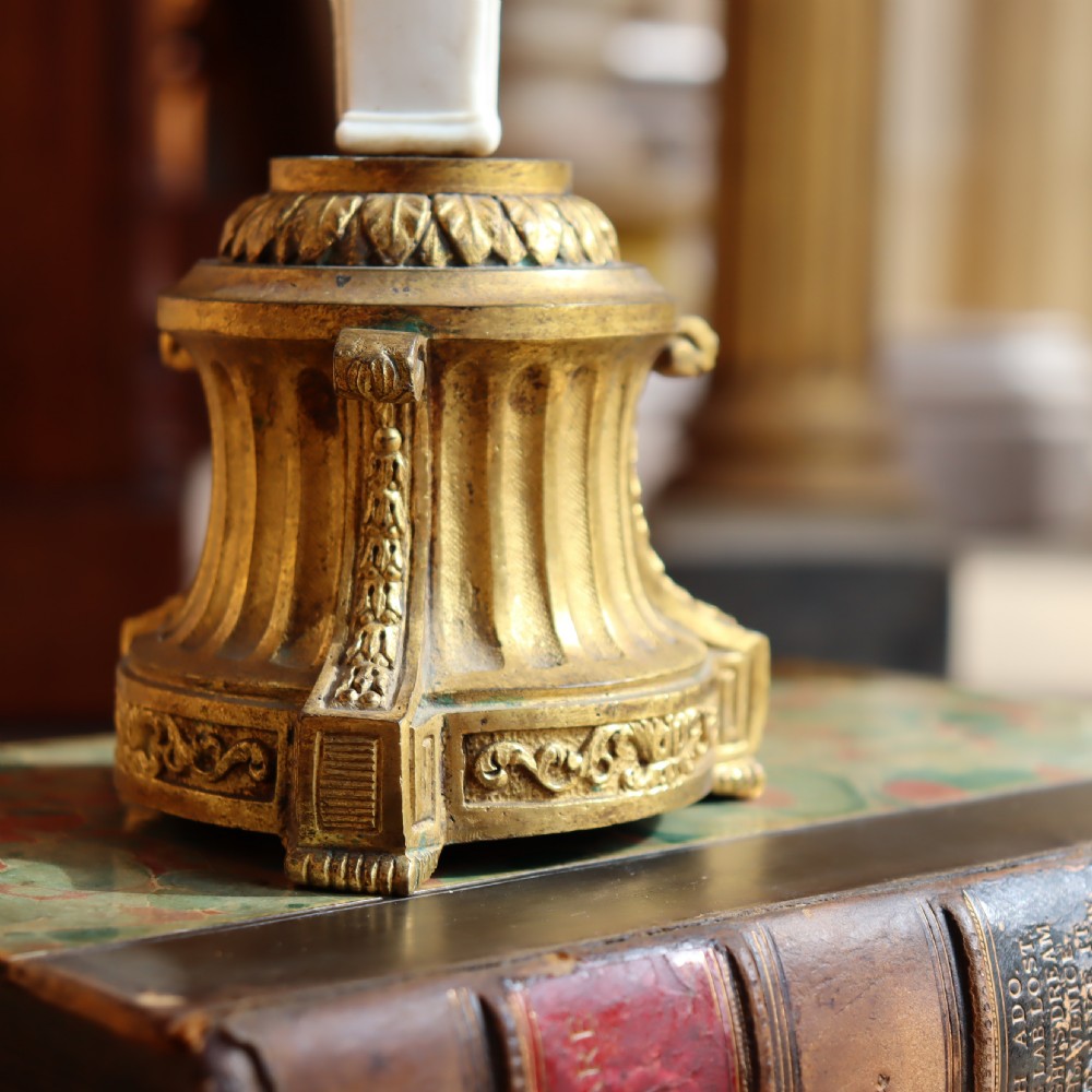 A 19th-century Neoclassical candlestick featuring a chased gilded bronze base and socket holding a sculpted white biscuit porcelain caryatid figure. View IV