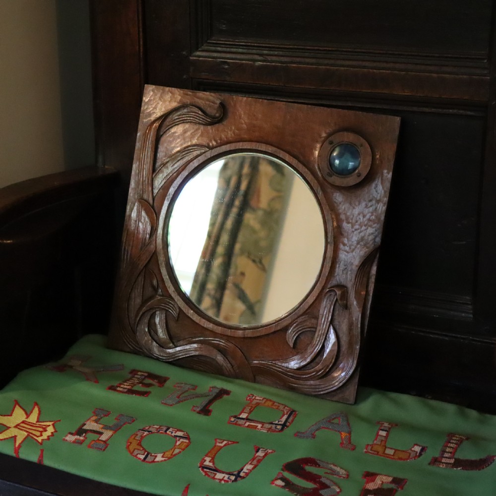 An Arts and Crafts carved wood wall mirror 