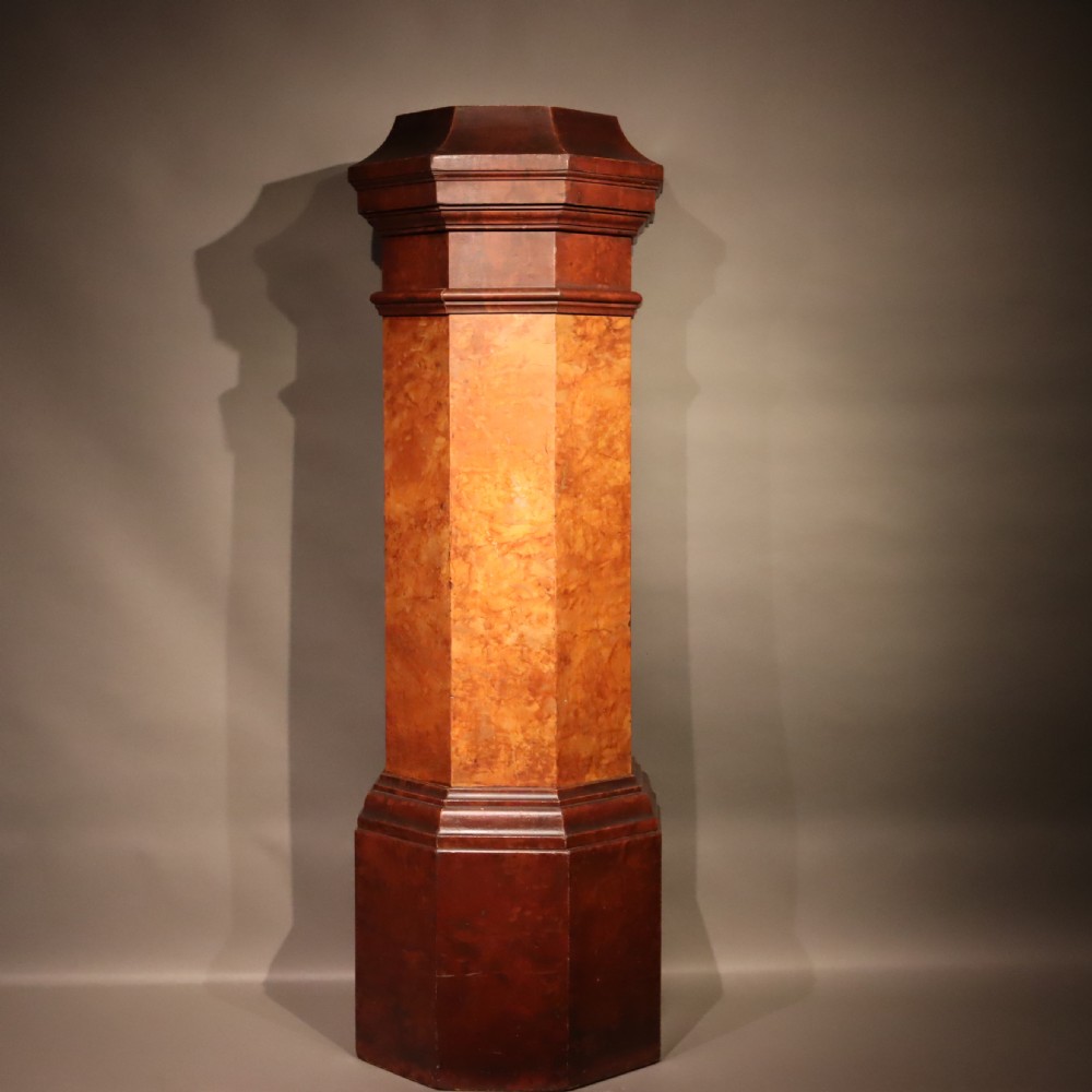 A tall octagonal Victorian column featuring a hand-painted faux marble shaft in warm ochre tones supported by a dark brown octagonal base and capital.