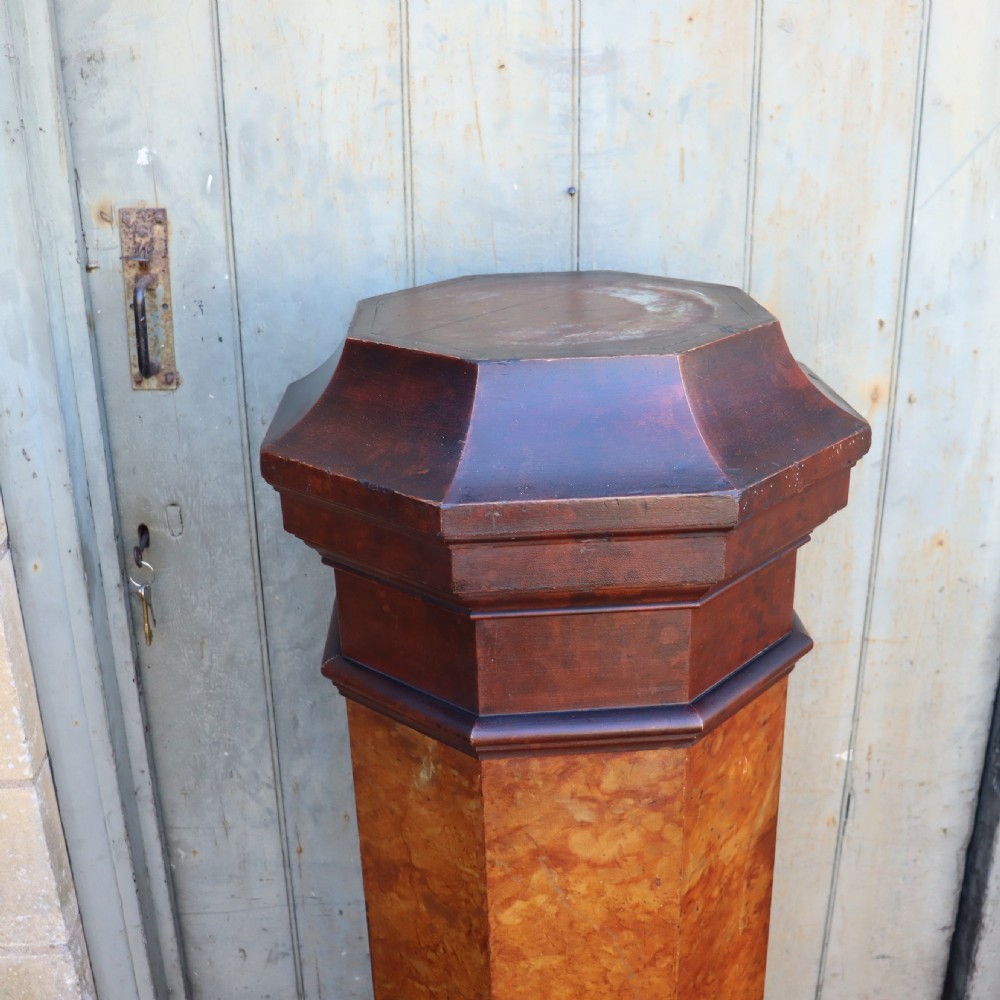 A tall octagonal Victorian column featuring a hand-painted faux marble shaft in warm ochre tones supported by a dark brown octagonal base and capital. View IV