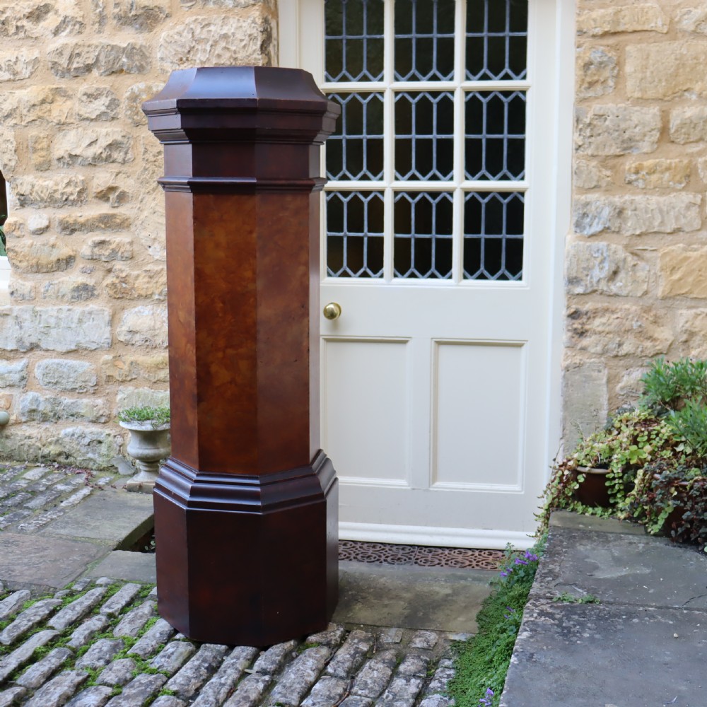 A tall octagonal Victorian column featuring a hand-painted faux marble shaft in warm ochre tones supported by a dark brown octagonal base and capital. View V