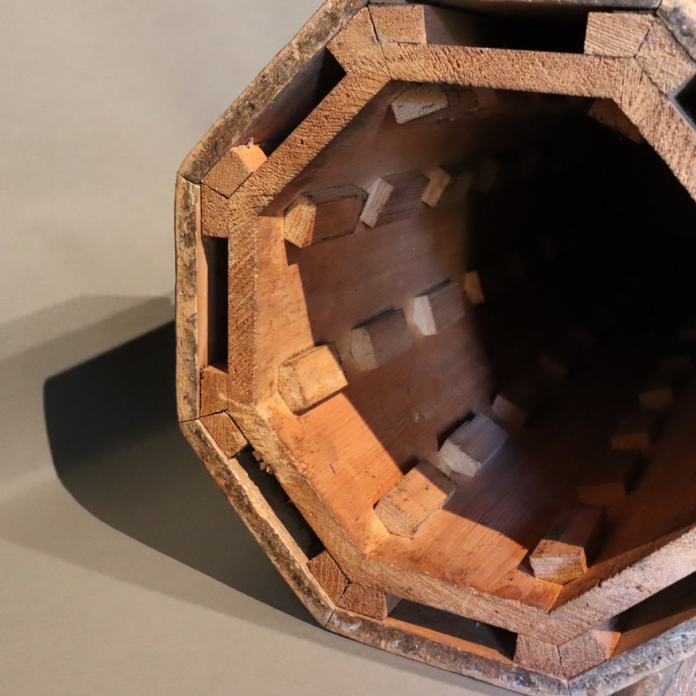 A tall octagonal Victorian column featuring a hand-painted faux marble shaft in warm ochre tones supported by a dark brown octagonal base and capital. View VI