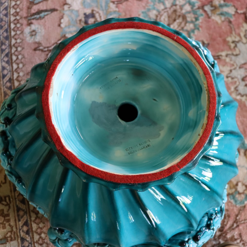 A bright turquoise glazed ceramic jardiniere with lion head swags resting on a matching winged griffin pedestal stand. View III