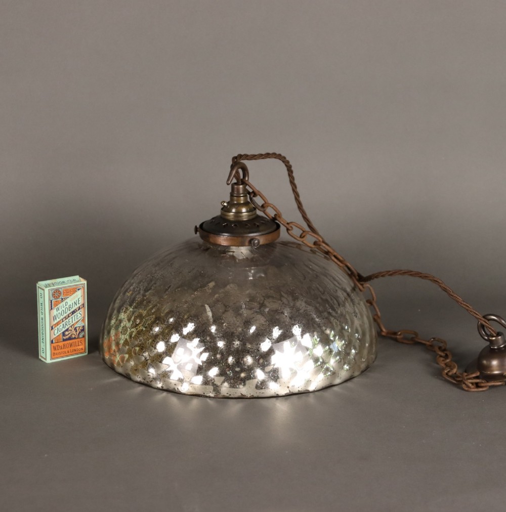 A dome-shaped mercury glass pendant light shade with a dappled silvered interior finish and aged brass fittings. View II