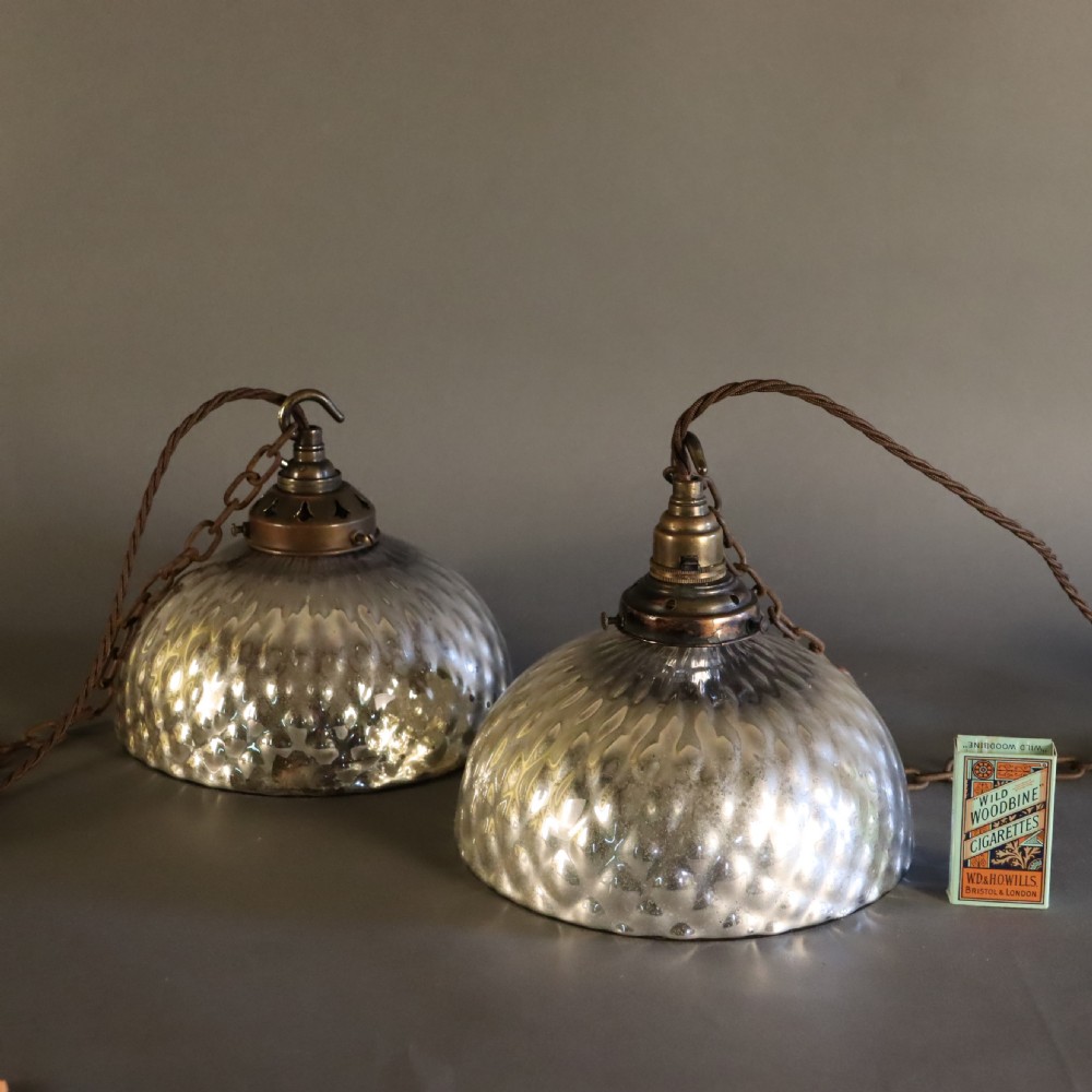 A pair of circa 1920 mercury glass pendant lights featuring textured silvered shades and dark brass galleries with hanging hooks. View III