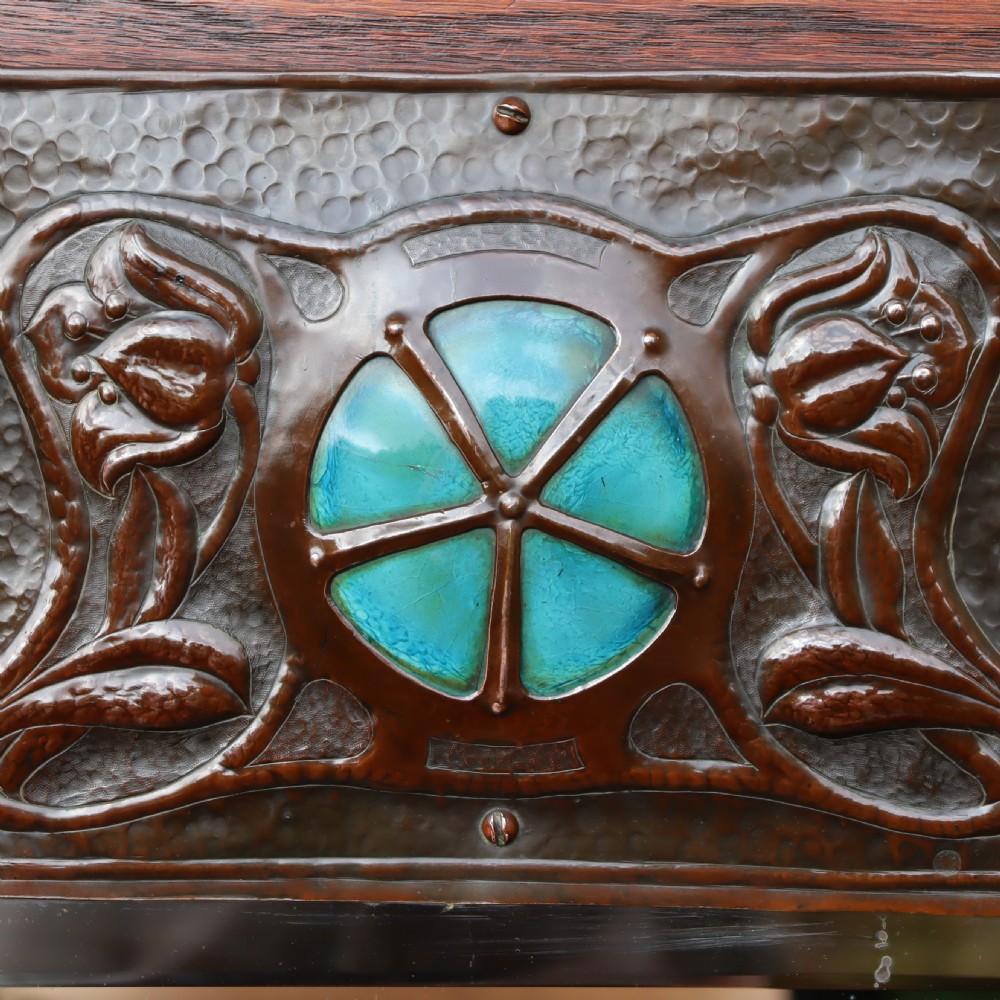An Arts and Crafts repoussé and oak framed mirror. View IV