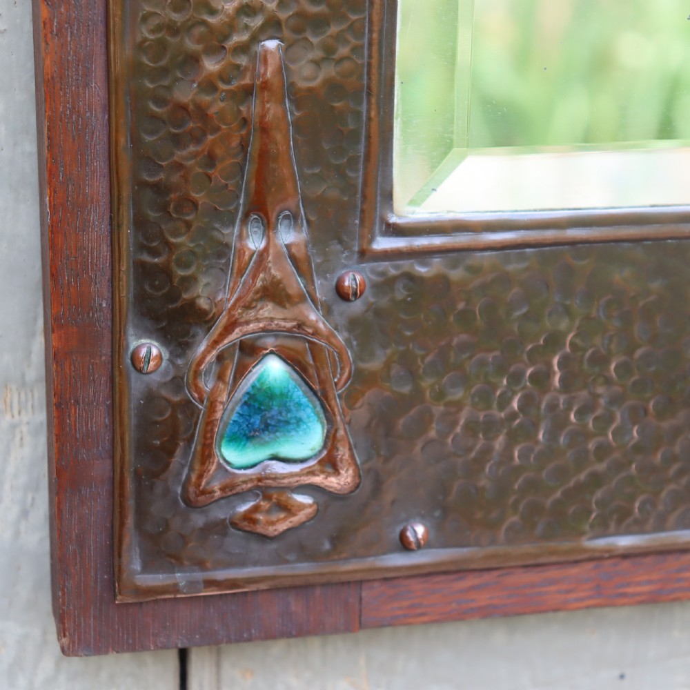 An Arts and Crafts repoussé and oak framed mirror. View V