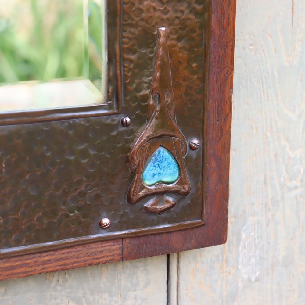 An Arts and Crafts repoussé and oak framed mirror. View VI