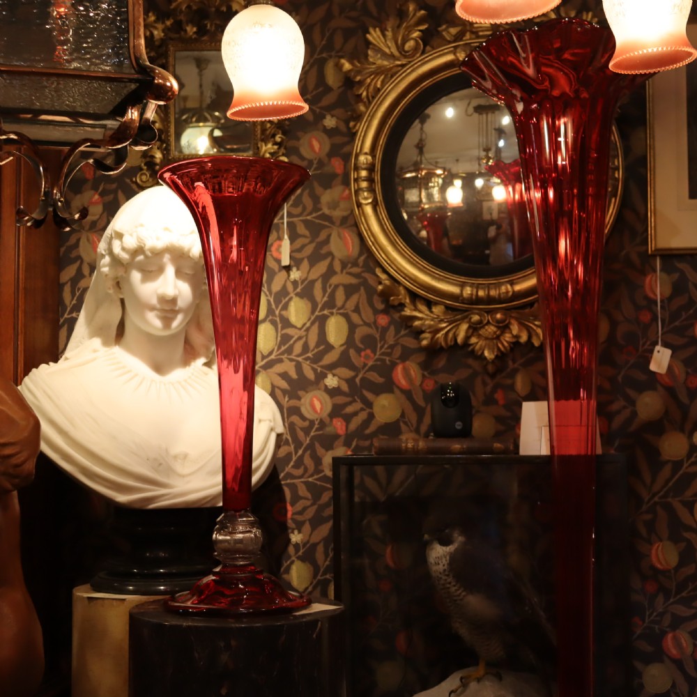 A tall Victorian trumpet-shaped vase made of deep red cranberry glass with a clear glass knop and circular foot. View X