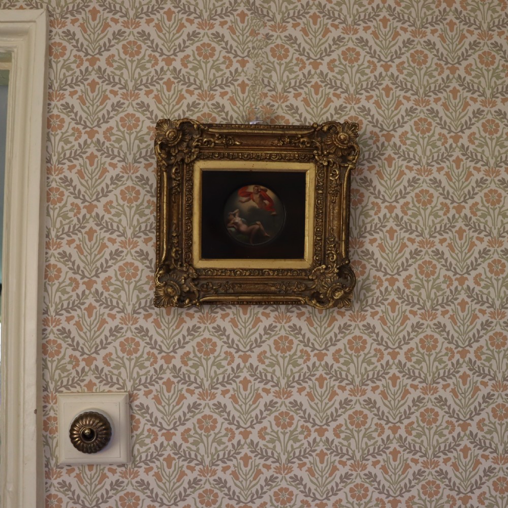 A small circular early 19th-century mythological oil painting depicting a reclining nude nymph and floating male god, encased in a square, highly ornate giltwood frame. View II