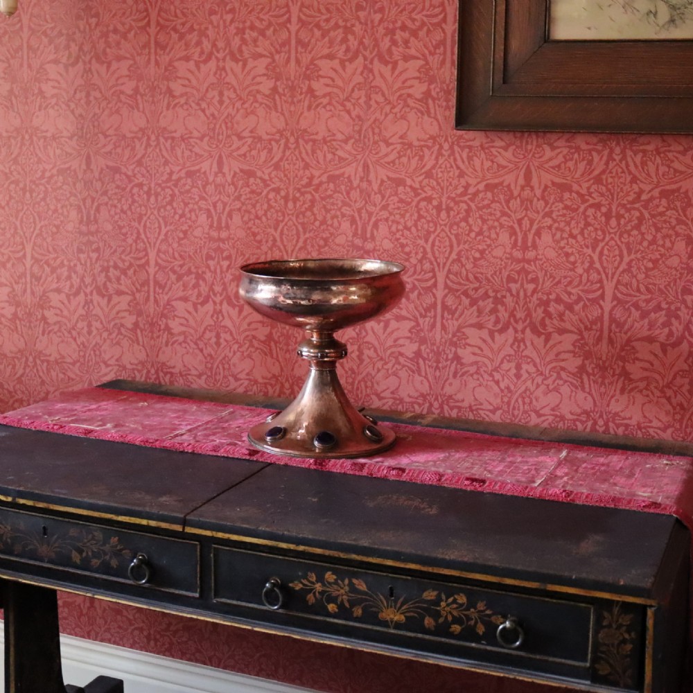 A hand-hammered copper pedestal bowl featuring a flared base set with circular blue enamel cabochons. View IV