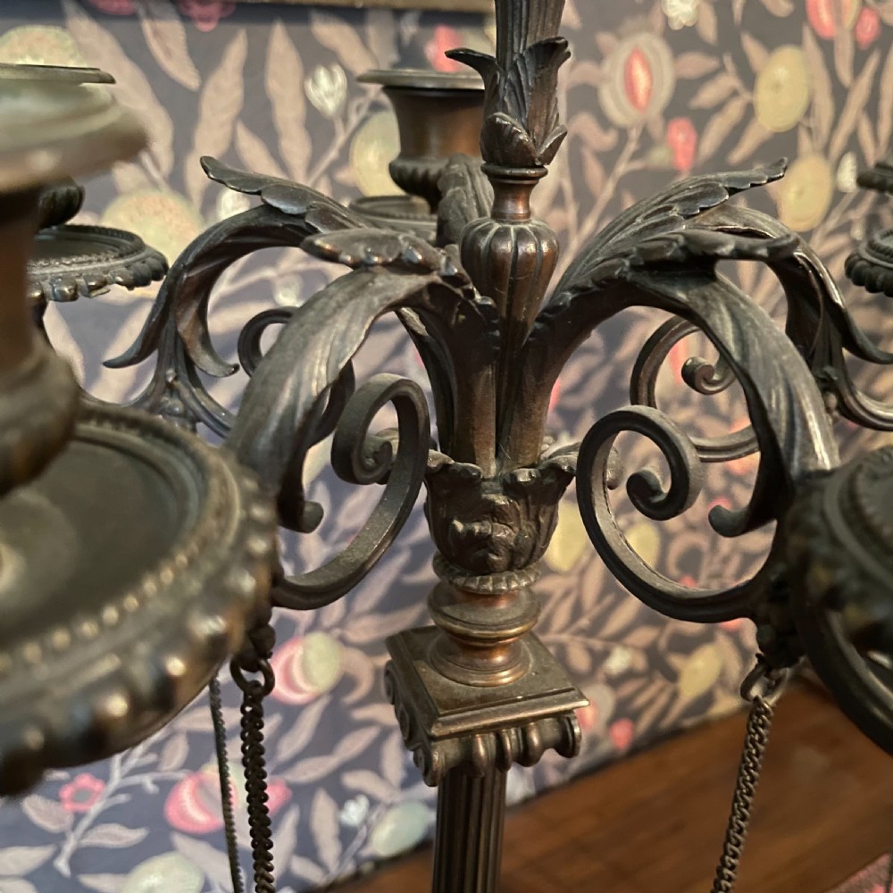 A pair of dark bronze Neoclassical candelabra featuring scrolling branches, bird finials, hanging chains, and black marble bases. View IV