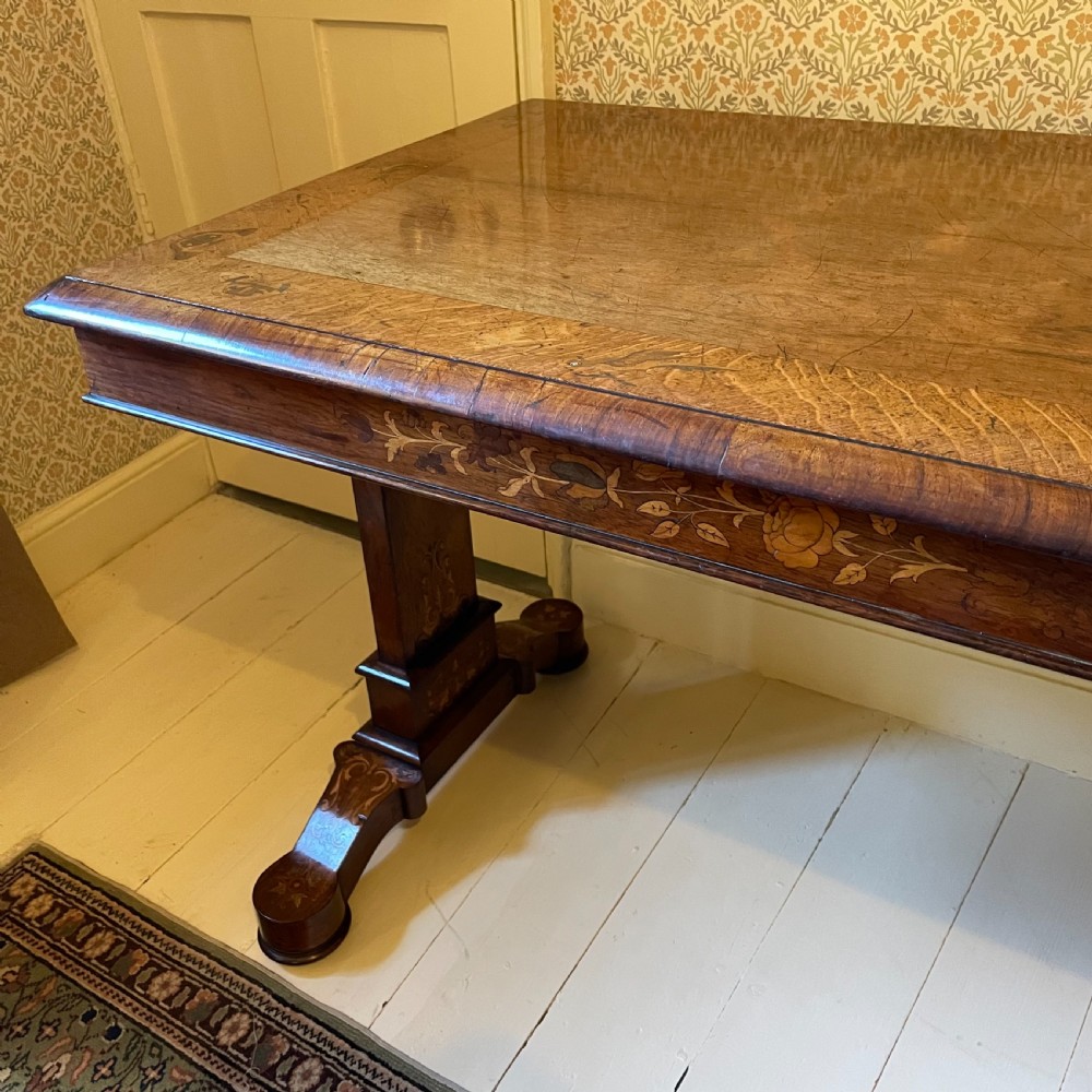 A Late Regency rectangular rosewood library table featuring inlaid floral marquetry along the frieze and pedestal supports. View II
