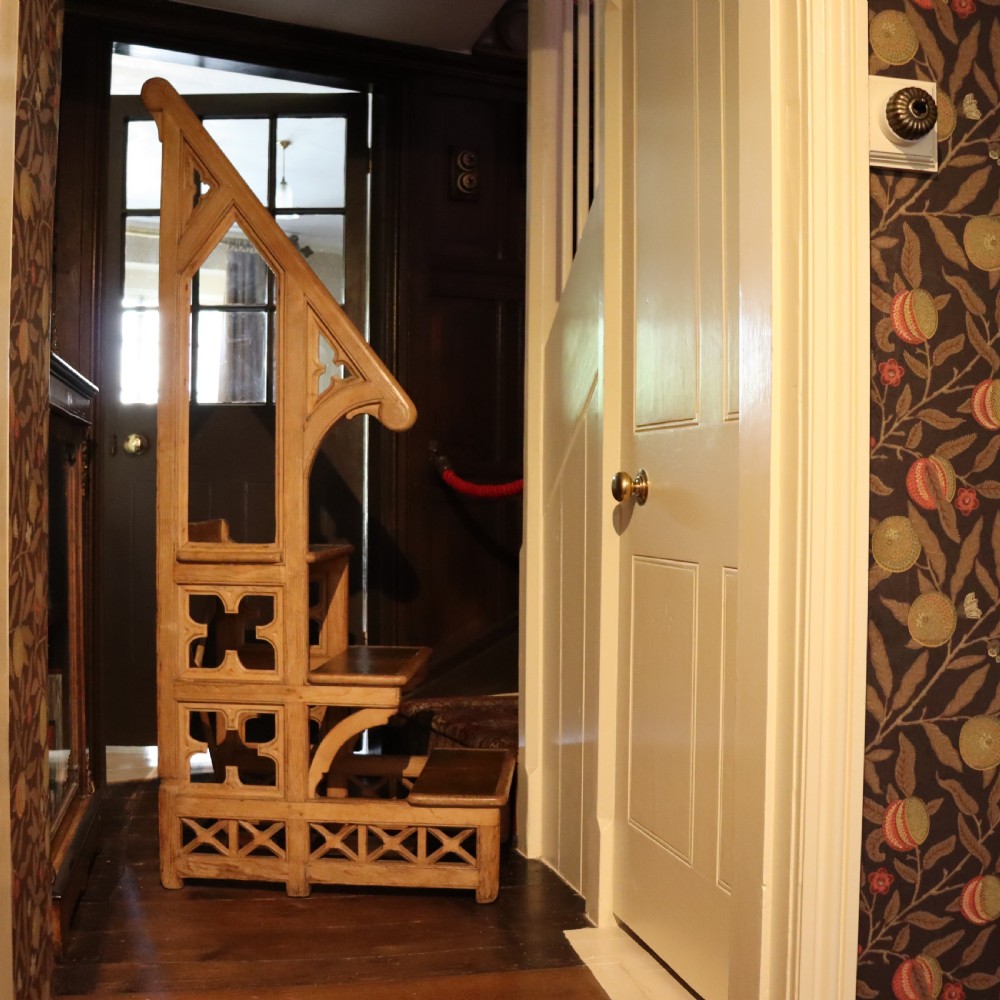 19th-century carved pine library steps featuring Gothic Revival pointed arches, quatrefoil cut-outs, and three stepped treads. View III