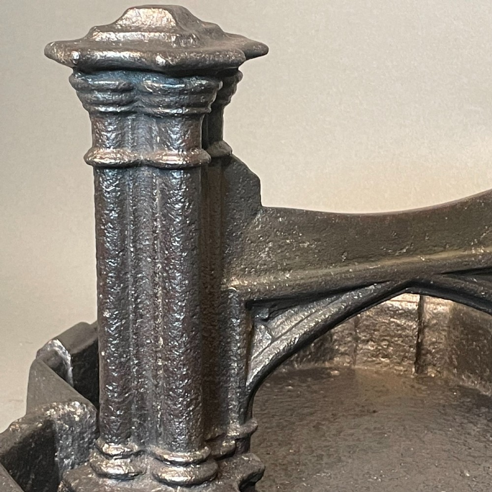 A heavy Victorian cast iron boot scraper featuring Gothic revival pointed arches, twin clustered columns, and an integrated tray base. View V