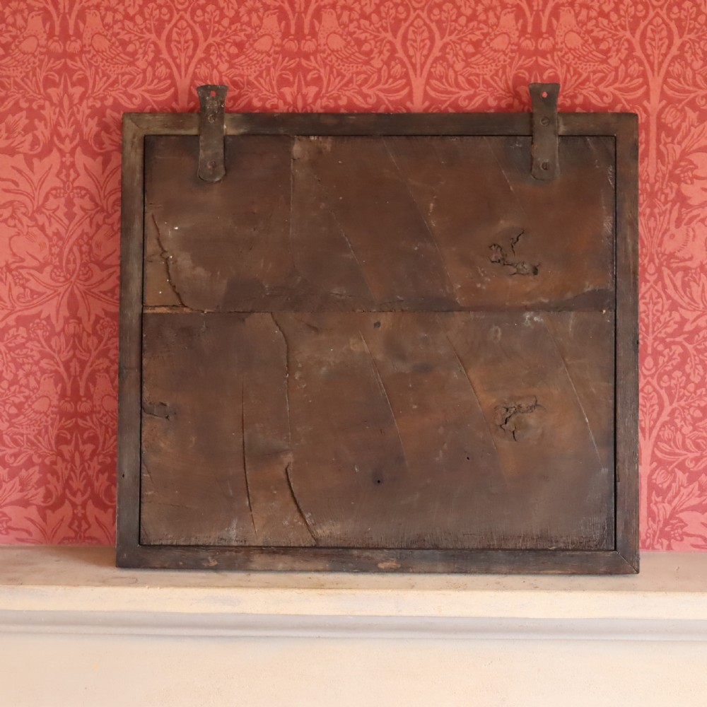 A square dark wood panel featuring a central relief of the British Royal coat of arms with gilded details and metal hanging fixtures at the top. View IV