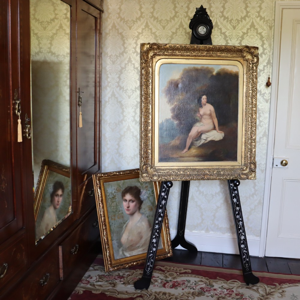 A tall black ebonised gallery easel decorated with white floral inlay along the legs and a carved medallion at the top crest. View III