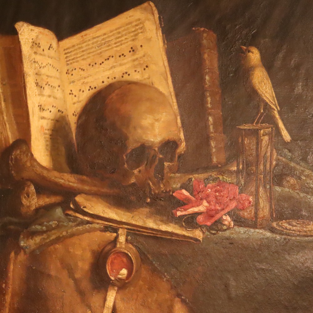 An oil painting depicting a vanitas still life with a human skull, open book, and hourglass set inside a dark moulded frame. View III