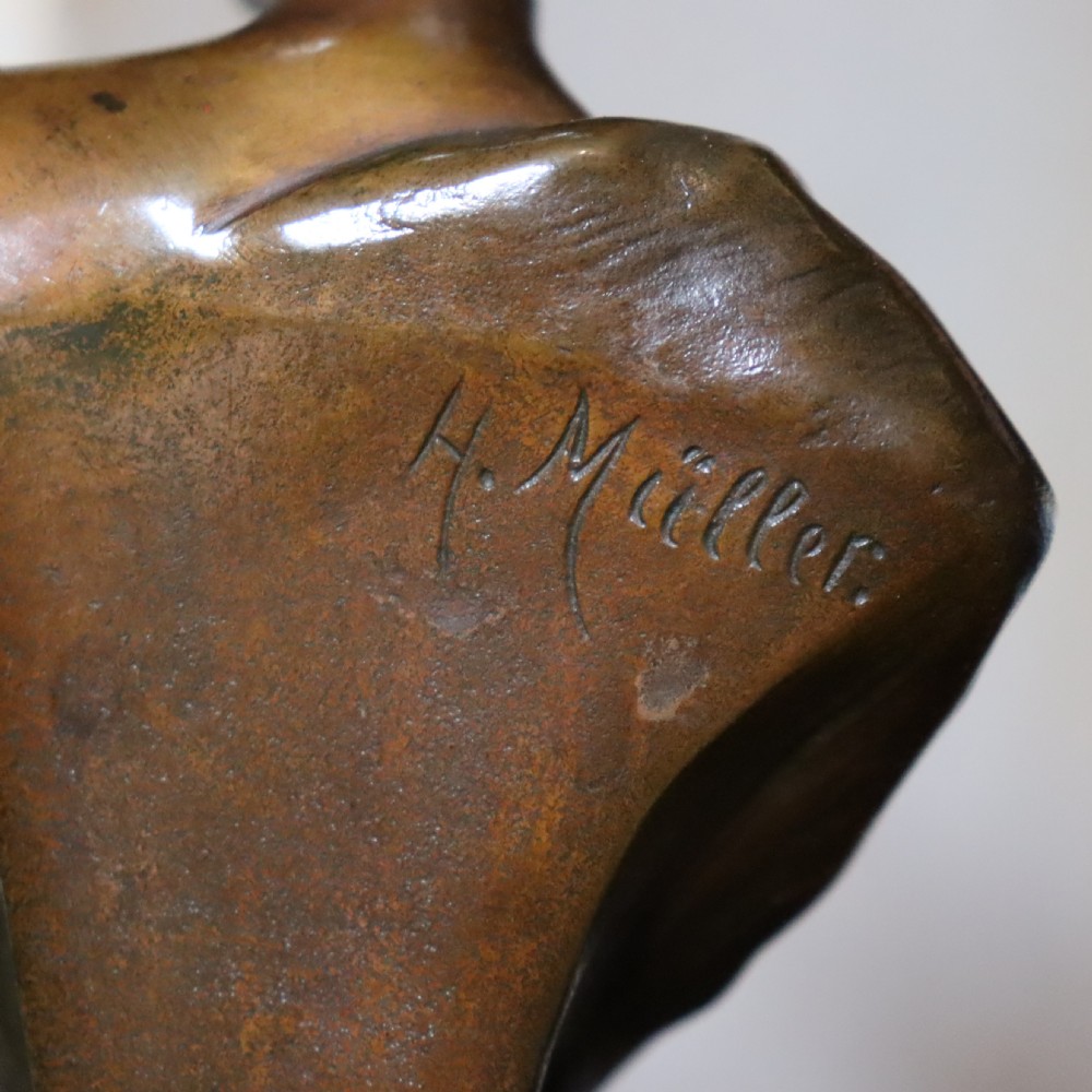 An Art Nouveau patinated bronze bust depicting a young woman adorned with ears of wheat and flowing drapery, set on a gilt base. View V