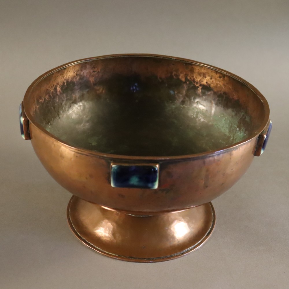 A hand-hammered copper pedestal bowl featuring rectangular blue-glazed ceramic cabochons mounted around the rim. View III