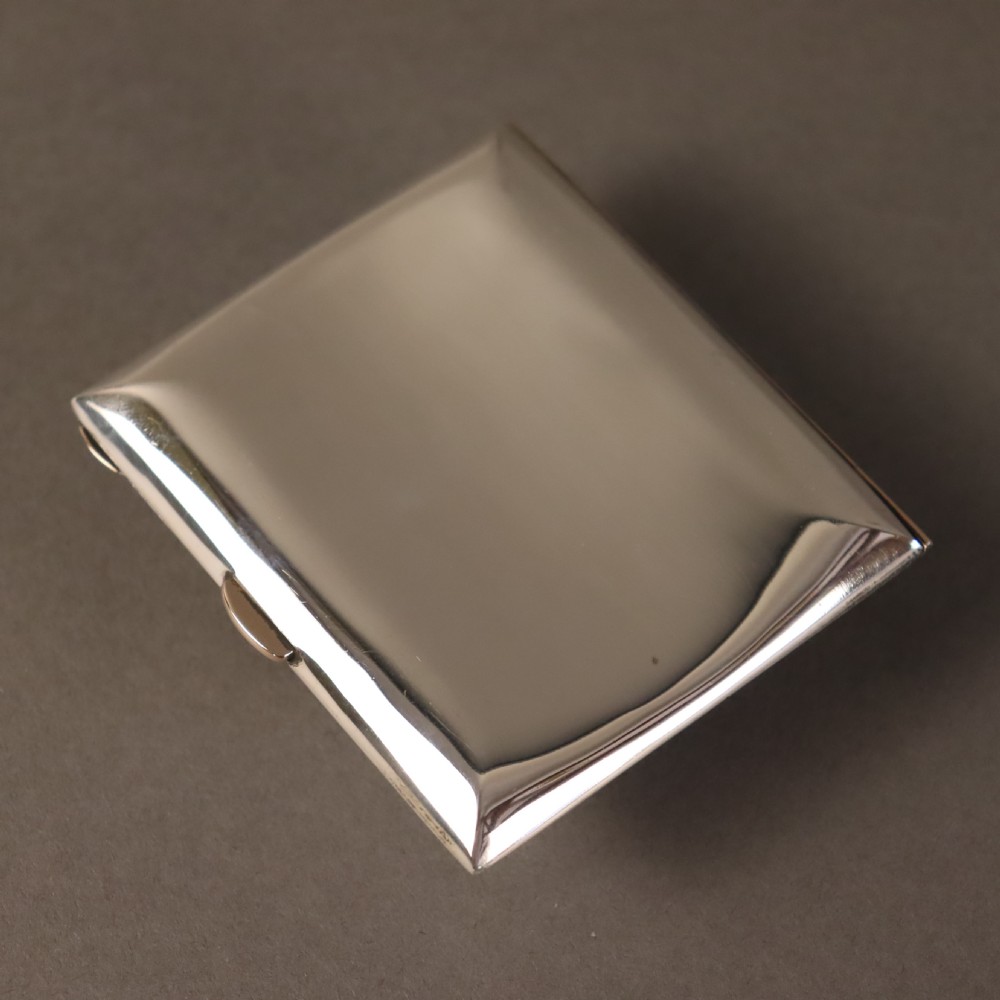 A rectangular planished sterling silver case featuring a raised Celtic knotwork motif filled with vibrant blue and green enamel. View IV