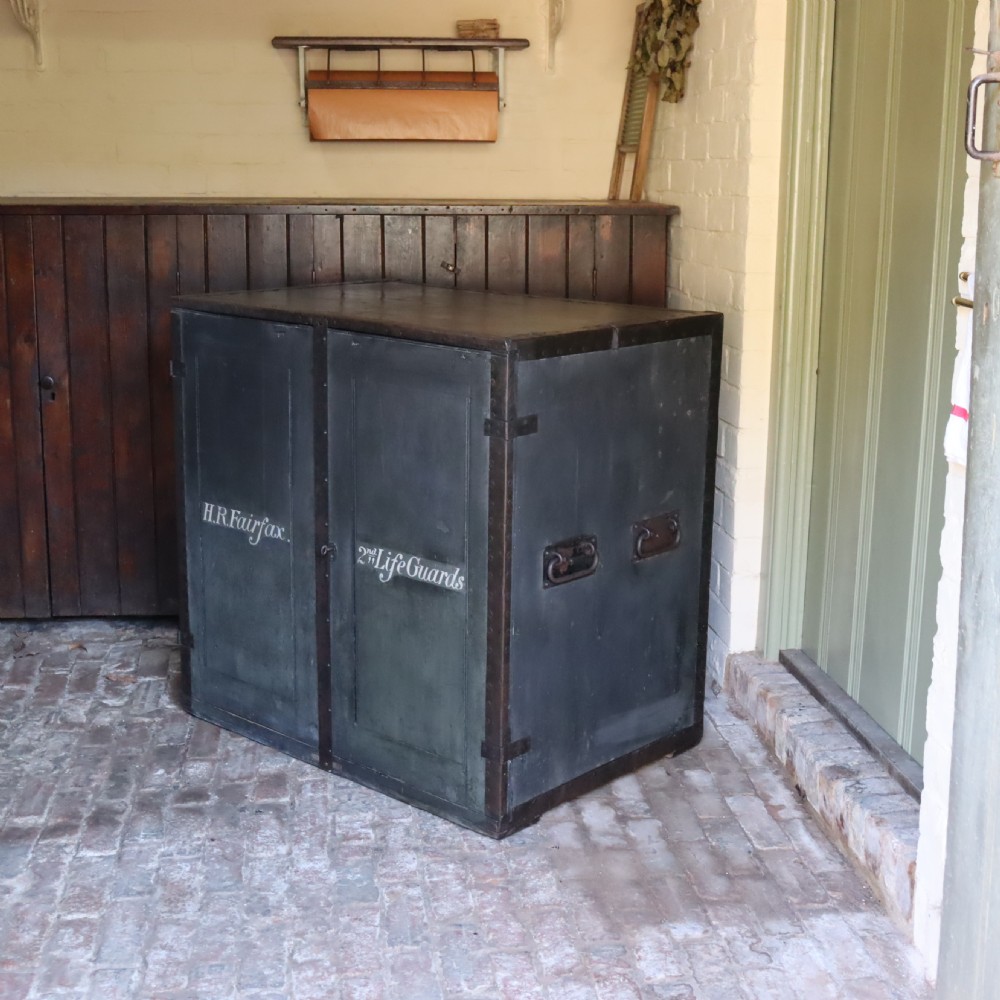 A large dark green metal-bound military campaign travelling case with stencilled lettering on the front panels and iron drop handles on the side. View III
