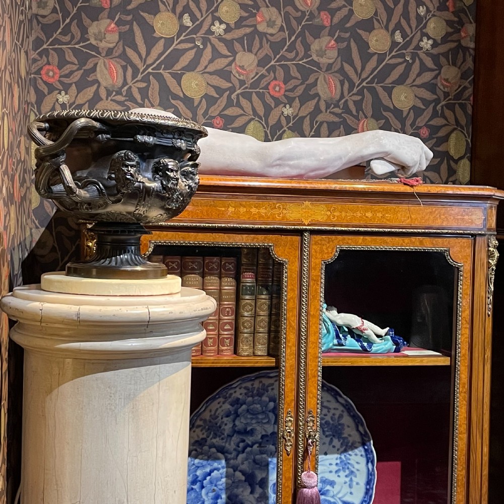 A dark patinated bronze Warwick vase featuring relief Bacchic masks, intertwined vine handles, and a gadrooned pedestal foot. View II