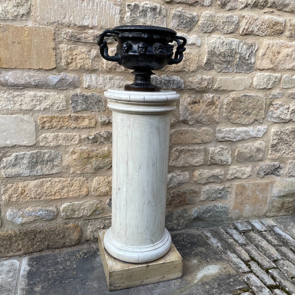 A dark patinated bronze Warwick vase featuring relief Bacchic masks, intertwined vine handles, and a gadrooned pedestal foot. View V